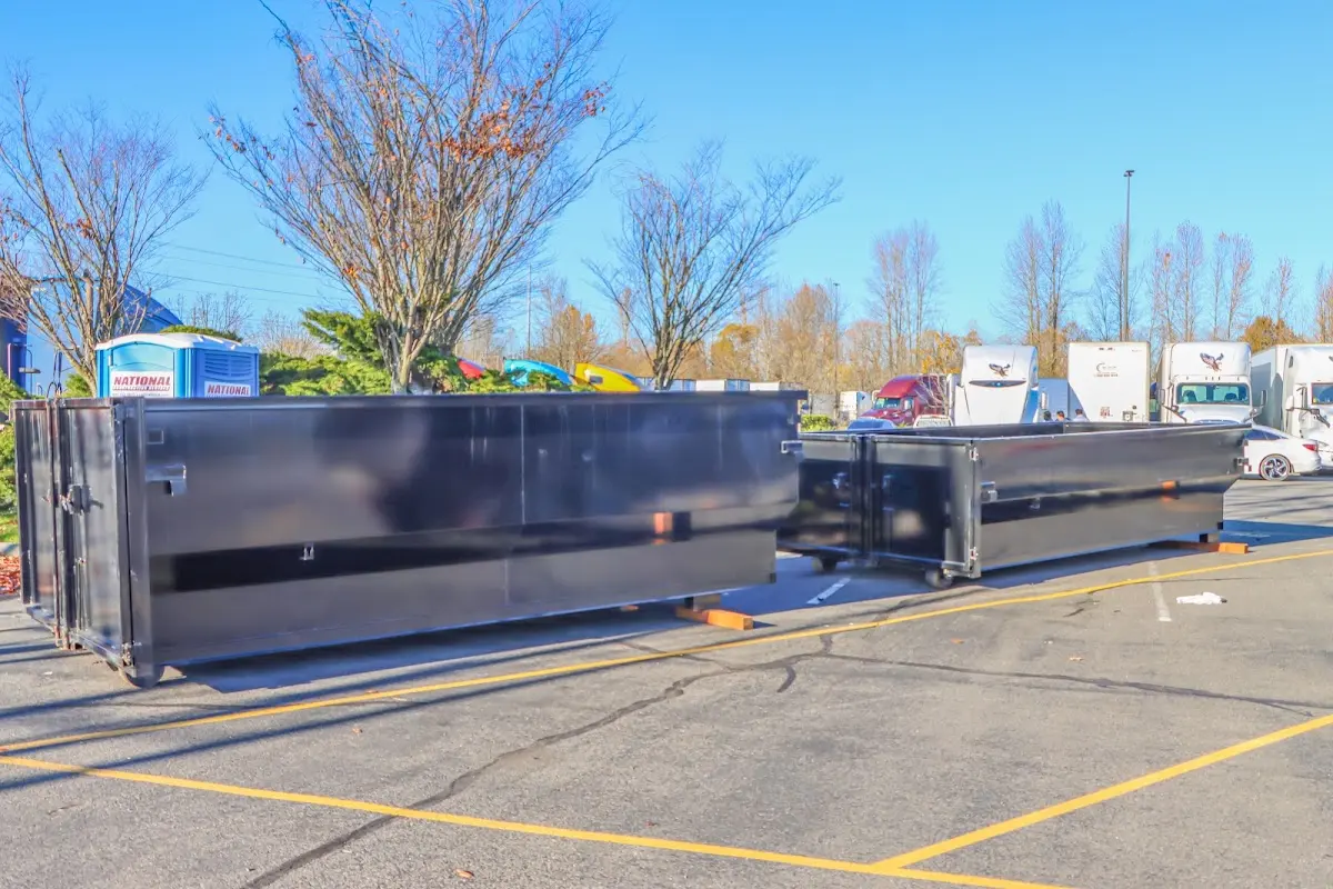 Professional dumpster rental service with roll-off container on residential driveway in Woodburn